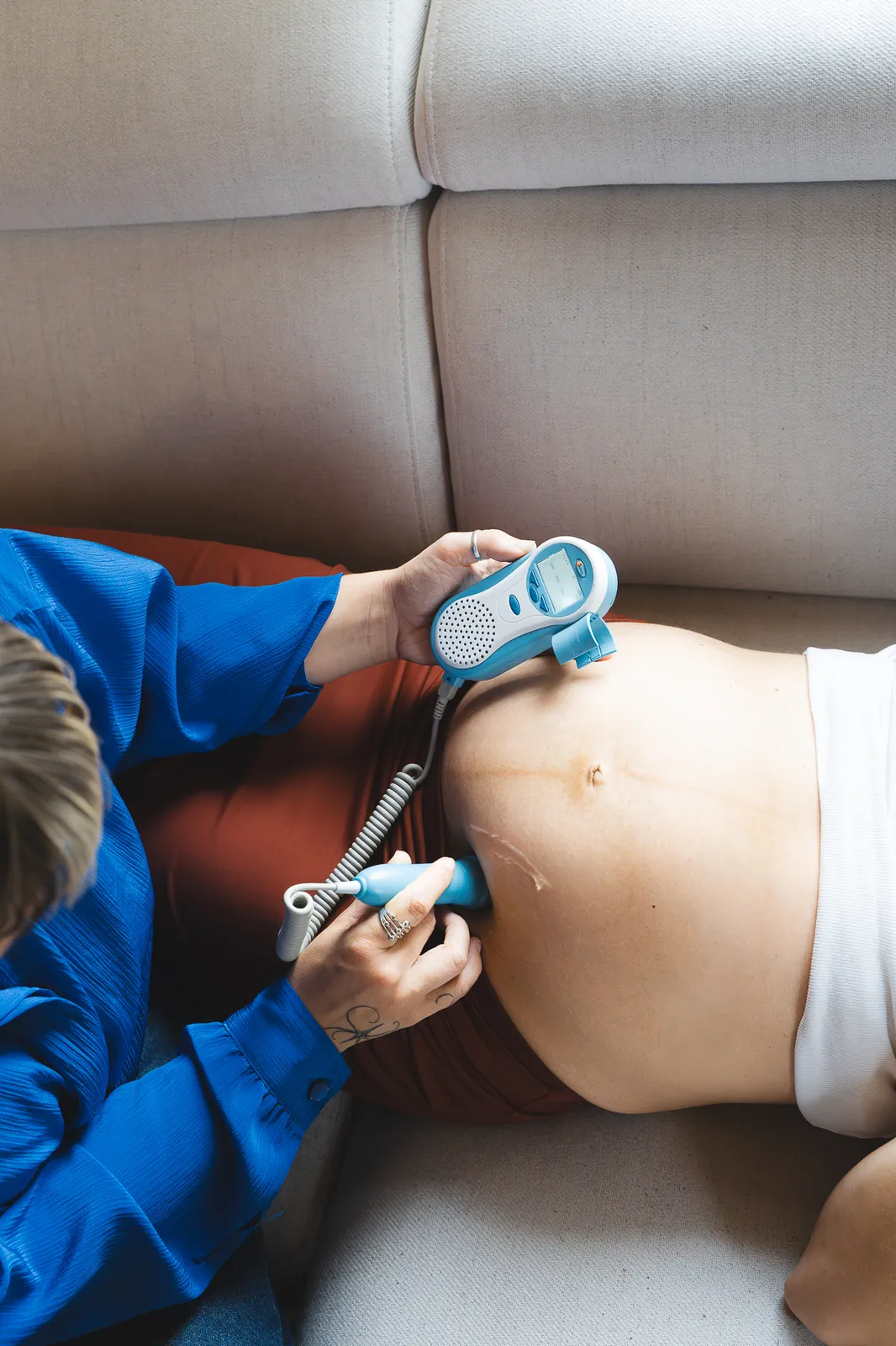 Hebamme hört bei einer Vorsorge die Herztöne des Babys ab